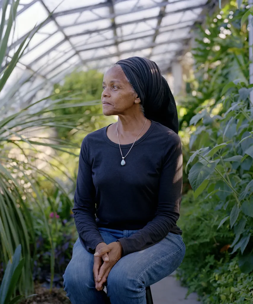 Paulette Henry, Co-founder of the Black Roots food growing enterprise in Haringey. Photographed in a fully planted greenhouse. 